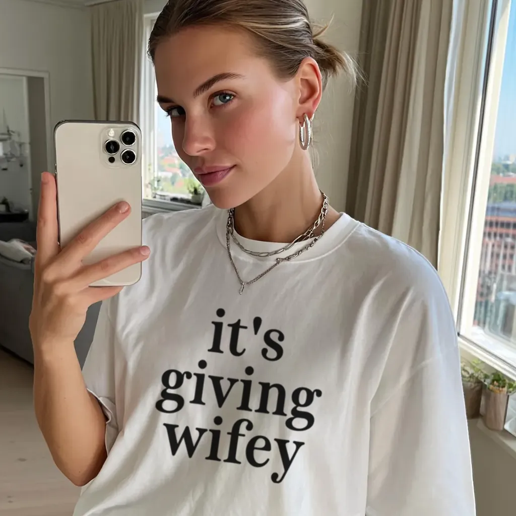 Woman wear Its Giving Wifey T-Shirt in white for bride to be bachelorette party outfit and honeymoon gift