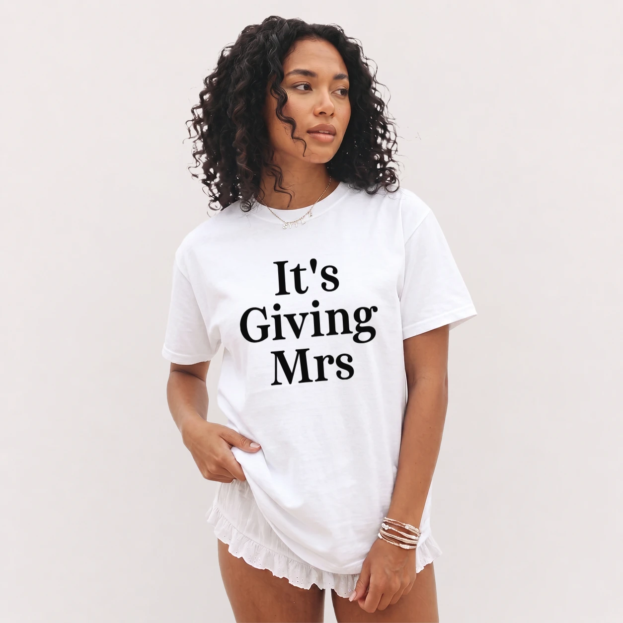 Bride wearing an It's Giving Mrs shirt with a modern bridal outfit