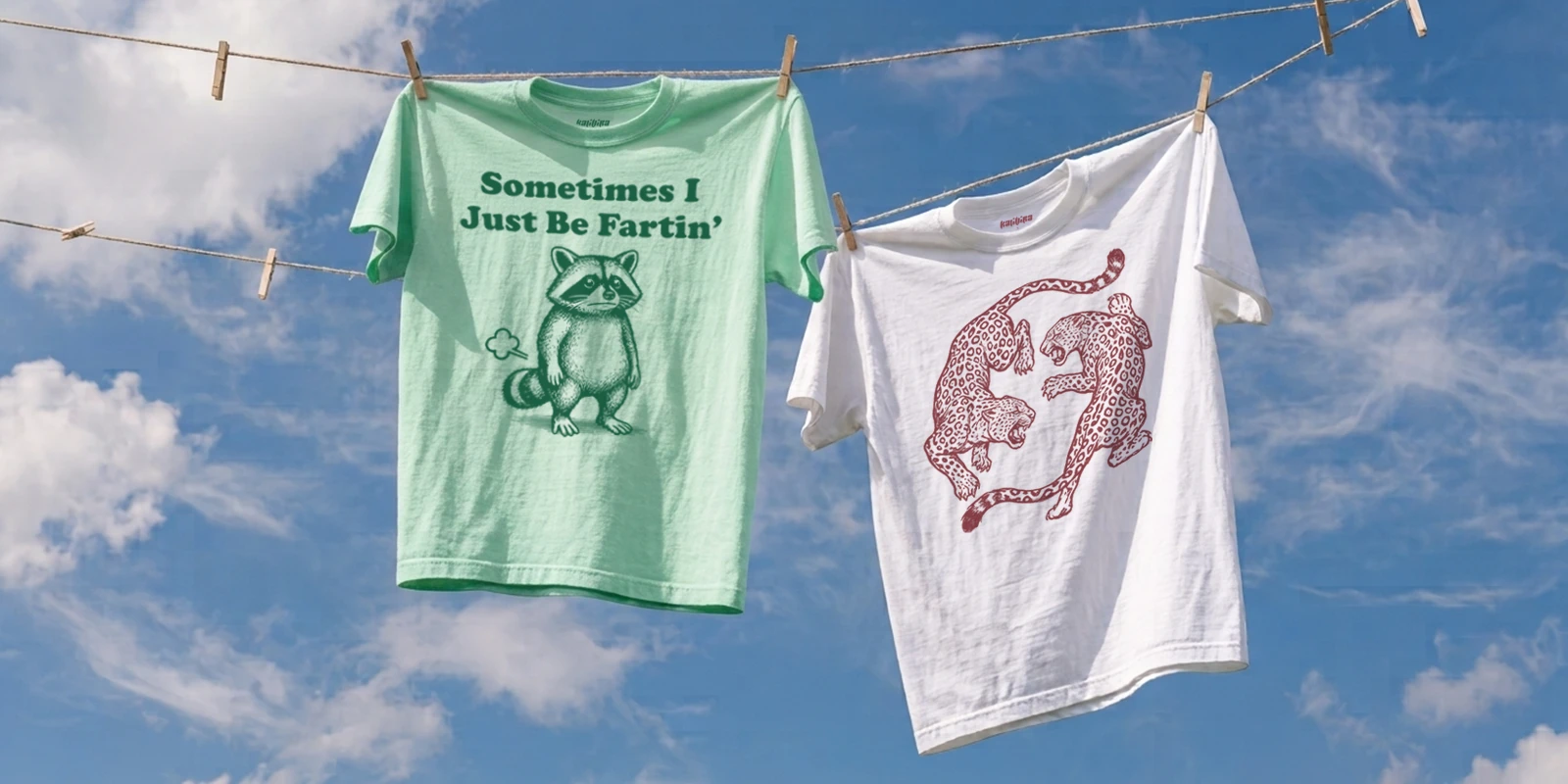 Graphic T-shirts hanging outdoors under a blue summer sky